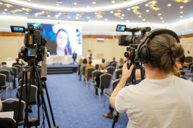 Kameraman, geniş oditoryumdaki iş semineri sırasında çevrimiçi hoparlörlerin konuştuğu profesyonel kamera kayıt videosu kullanıyor.