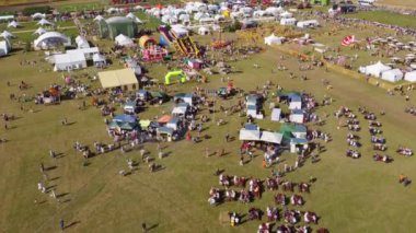 Kaliningrad, Rusya - 6 Ağustos 2022: Yukarıdan bakıldığında, yaz günü fuarda lunapark gezileri ve çadırlarda yürüyen insanlar görülüyor