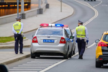 Moskova, Rusya - 6 Ağustos 2022: Trafik polisi üniformalı adamların şehir caddesinde çalışırken yol ve kaldırımlarda parlayan sinyallerle yürüdükleri arka plan