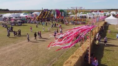 Kaliningrad, Rusya - 6 Ağustos 2022: Güneşli yaz günlerinde fuar sırasında insanların saman duvarlarıyla çevrili bir alana girip çıkmalarına bir göz atın