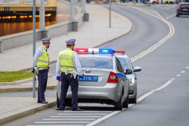 Moskova, Rusya - 6 Ağustos 2022: Trafik polisi üniformalı adamların şehir caddesinde çalışırken yol ve kaldırımlarda parlayan sinyallerle yürüdükleri arka plan