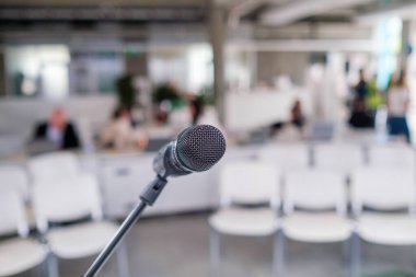 Halka açık etkinliğin başlangıcında boş koltuklara mikrofon yerleştirilmiş standın yumuşak odağı