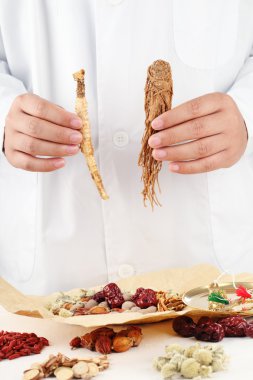 Doctor showing Chinese traditional herbal medicine. clipart