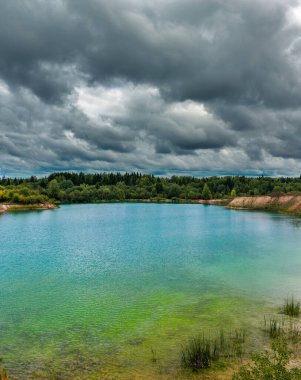 Kasvetli bir yaz gününde, ormanın yakınında bir göl.