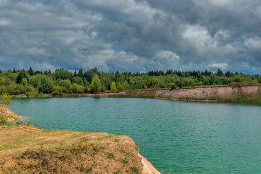 Bulutlu bir yaz gününde, kireçtaşı ocağında göl