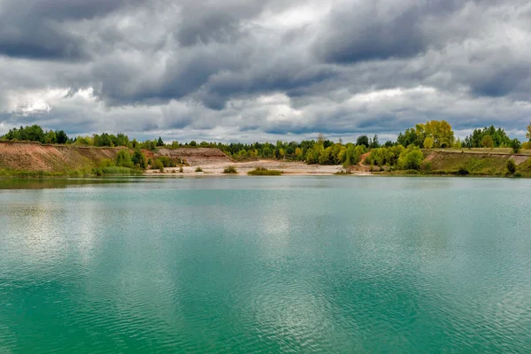 Lago en la cantera de piedra caliza en un sombrío día de verano nublado — Foto de Stock
