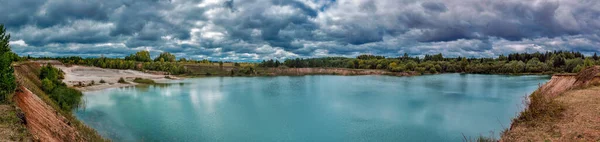 Jezero v vápencovém lomu v zamračeném, ponurém letním dni — Stock fotografie