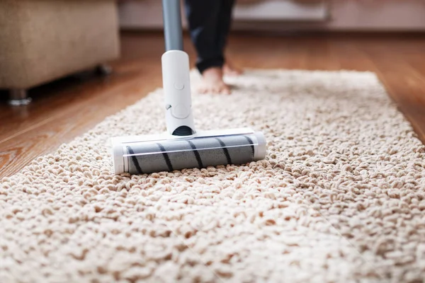A vacuum cleaner brush cleans a fleecy carpet, top view