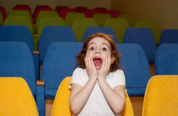 Nettes hübsches kleines Mädchen sitzt im Kinosaal — Stockfoto