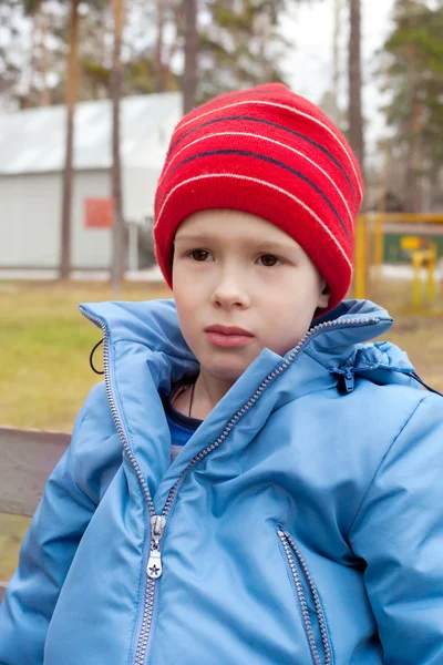 Jongen in het GLB en de vacht buitenshuis — Stockfoto