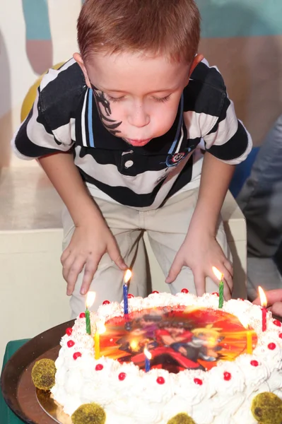 Boy blowing the birthday cake candles — Stock Photo, Image