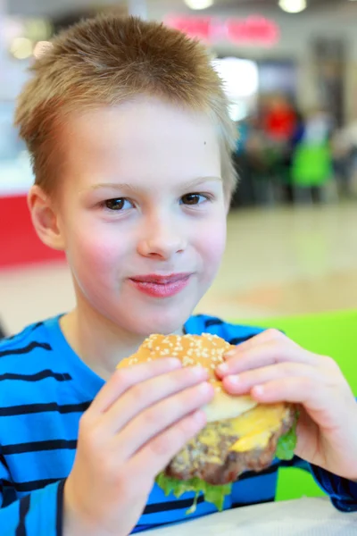 Petit garçon manger un hamburger — Photo
