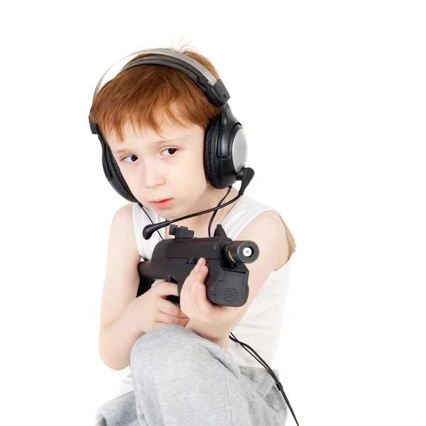 Boy in headphones playing with the pistol — Stock Photo, Image