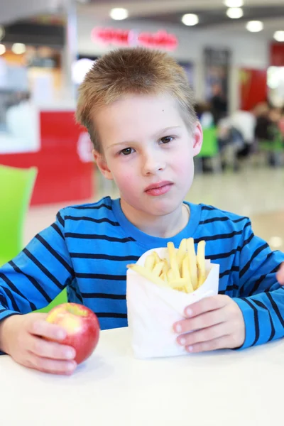 Jongen met de french-fried aardappelen en apple — Stockfoto