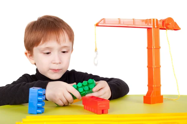 Хлопчик грає з іграшковим підйомним краном — стокове фото