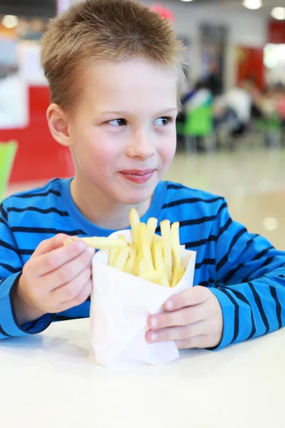 Pojke med french-fried potatis — Stockfoto