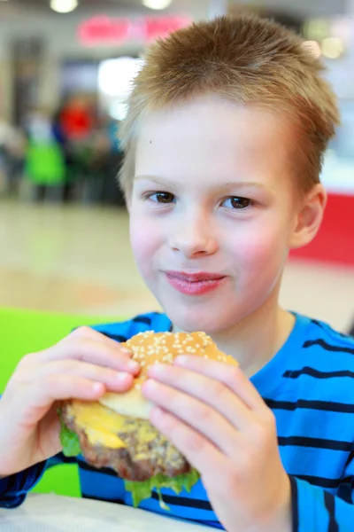 Junge isst Burger — Stockfoto