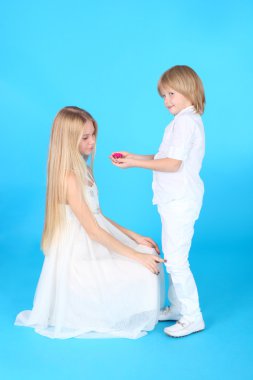 küçük çocuk bir çiçek kız kardeşiyle vererek