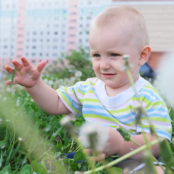 Lilla barnet sitter i gräset — Stockfoto