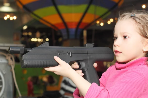Flicka som leker med stor pistol — Stockfoto