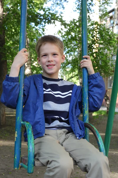 Kleine jongen swingen in het park — Stockfoto