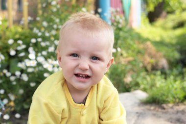 Çocuğun yanında çiçekler