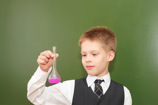 Menino com o tubo de agente químico rosa — Fotografia de Stock