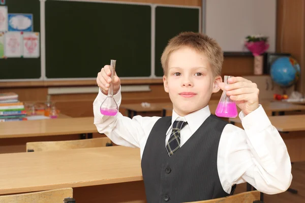 Ragazzo con i tubi di agente chimico rosa — Foto Stock