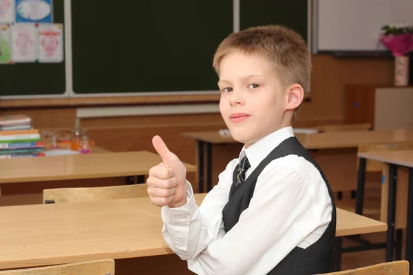 Мальчик в классе с поднятыми пальцами — стоковое фото