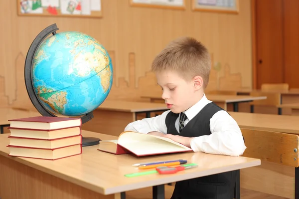 Junge liest Buch im Klassenzimmer — Stockfoto