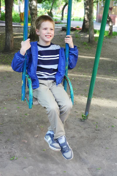 Kleine jongen swingen in het park — Stockfoto