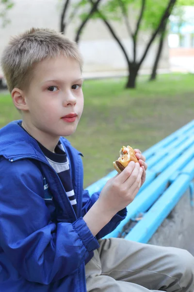 Pojken äta hamburgare — Stockfoto