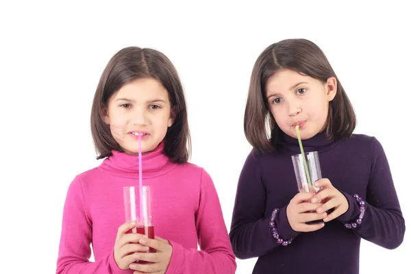 Kleine Zwillingsschwestern trinken Saft — Stockfoto