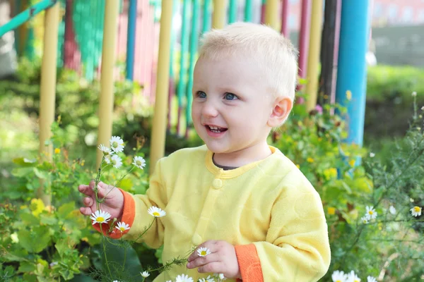 Niño oliendo las flores — Foto de Stock