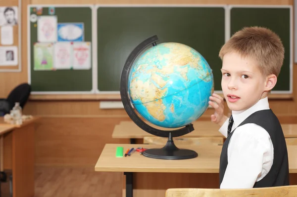 Kleiner Junge in der Nähe einer Erdkugel im Klassenzimmer — Stockfoto