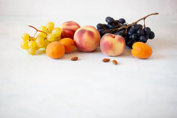Frutta fresca e mandorle sullo sfondo bianco Foto Stock
