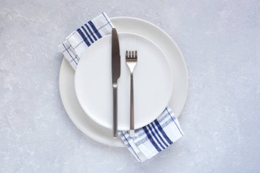 Gri arkaplanda mat plakaları ve çatal bıçak takımı, üst görünüm, boşluk kopyala