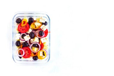 Beyaz arka planda Yunan salatası, sağlıklı yiyecek ve sıfır atık içeren beslenme çantası, üst görünüm, kopyalama alanı