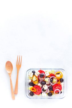 Yunan salatası, ahşap çatal bıçak, beyaz arka plan, üst görünüm, fotokopi alanı, sağlıklı yiyecek konsepti ve sıfır atık