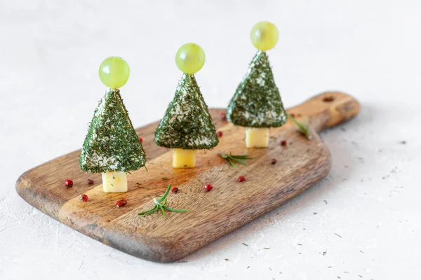 开胃菜 新年树 奶酪制成 装饰有丁香和葡萄 烹调简单 在木板上 侧面看 图库图片