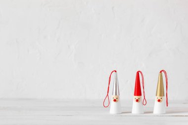 Beyaz ahşap arka planda üç Noel Baba figürü, yan görünüş, kopyalama alanı