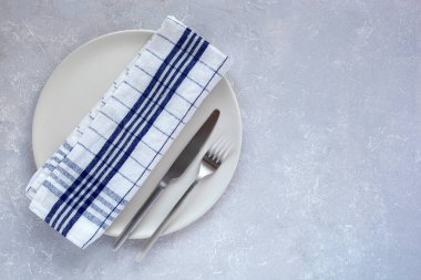 Gri arkaplanda mat plakaları ve çatal bıçak takımı, üst görünüm, boşluk kopyala