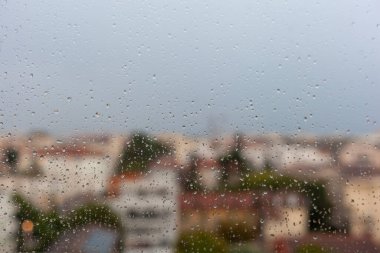 Avrupa şehir manzarası penceredeki yağmur damlalarından, sonbahar şehir manzarasından
