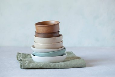 Yeşil tekstil keten peçeteye seramik ve kumtaşı boş doğal renk kaseleri yığını