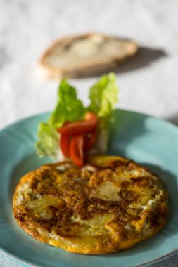 tortilla espanola on a plate with tomato