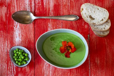 Kırmızı ağaçta kremalı bezelye çorbası.