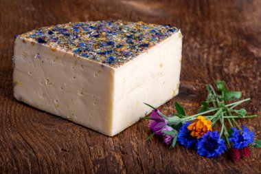 Ahşap üzerinde çiçekler olan dağ peyniri