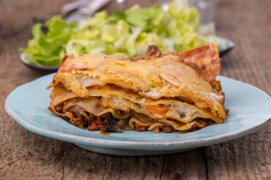 Koyu ahşap salatalı lazanya.