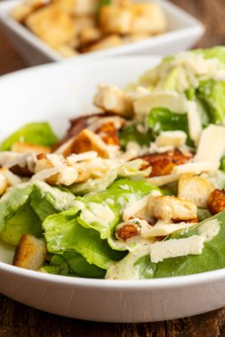 caesar salad on dark wood