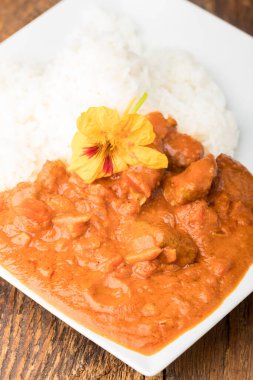 Nasturtiyum çiçekli körili tavuk.